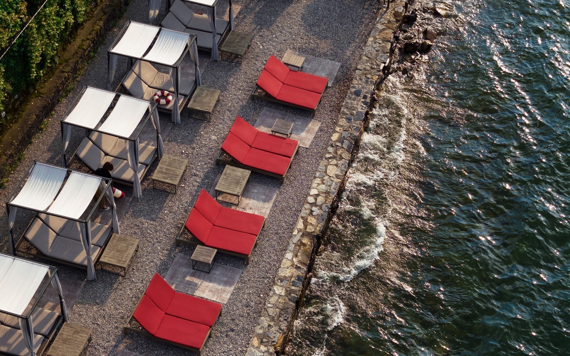 Loungers and daybeds on the lakeshore at Filario Hotel & Residences, from above