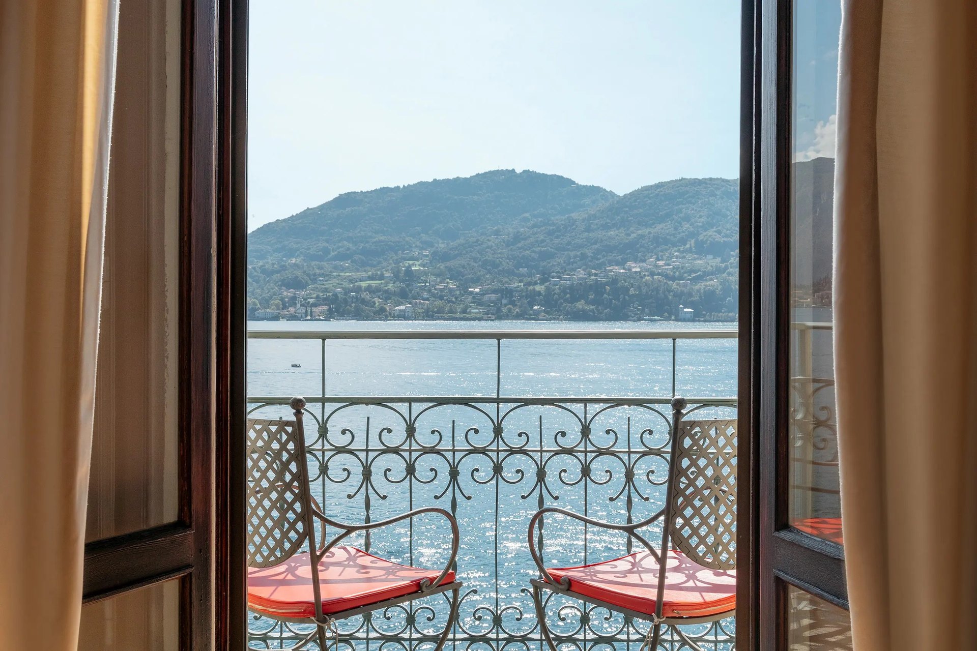 A balcony at the Grand Hotel Tremezzo, with two chairs and a wrought-iron rail looking across the lake