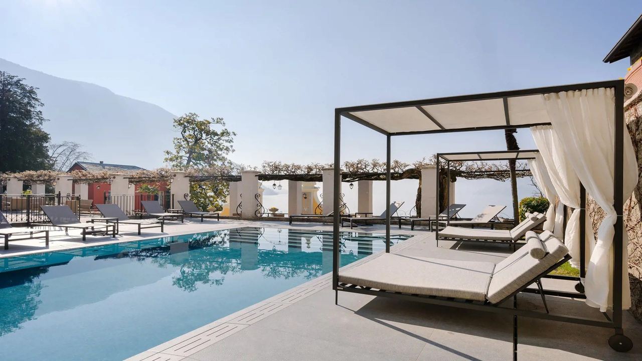 The pool and canopied daybeds of the Hotel Royal Victoria in Varenna, under a wisteria pergola